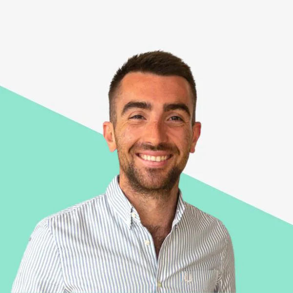 Smiling man in a striped shirt on a colorful background.