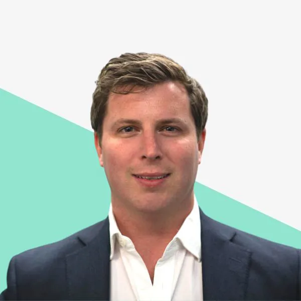 Man in a suit against a geometric background.