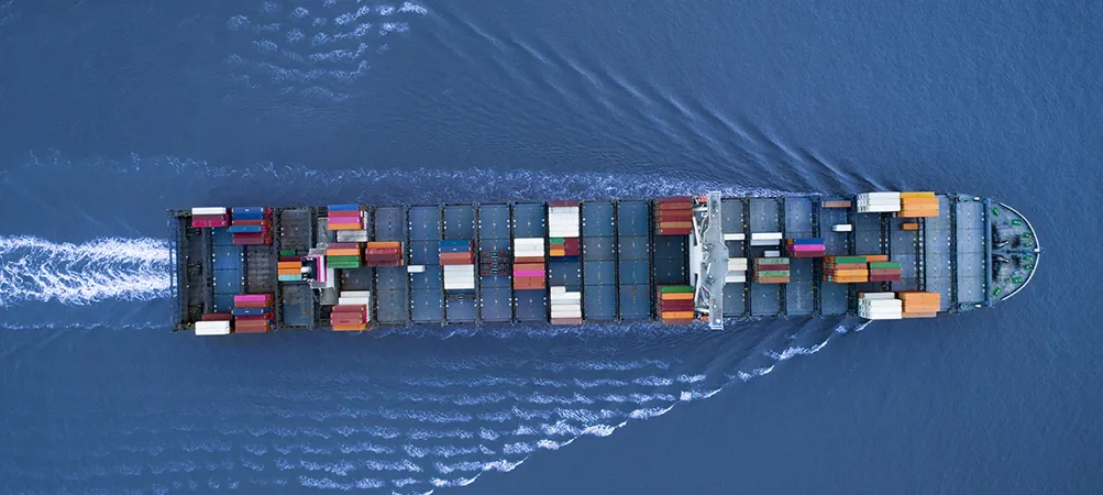 a Large container ship is approaching the port full loaded with containers and cargo, aerial, top down view
