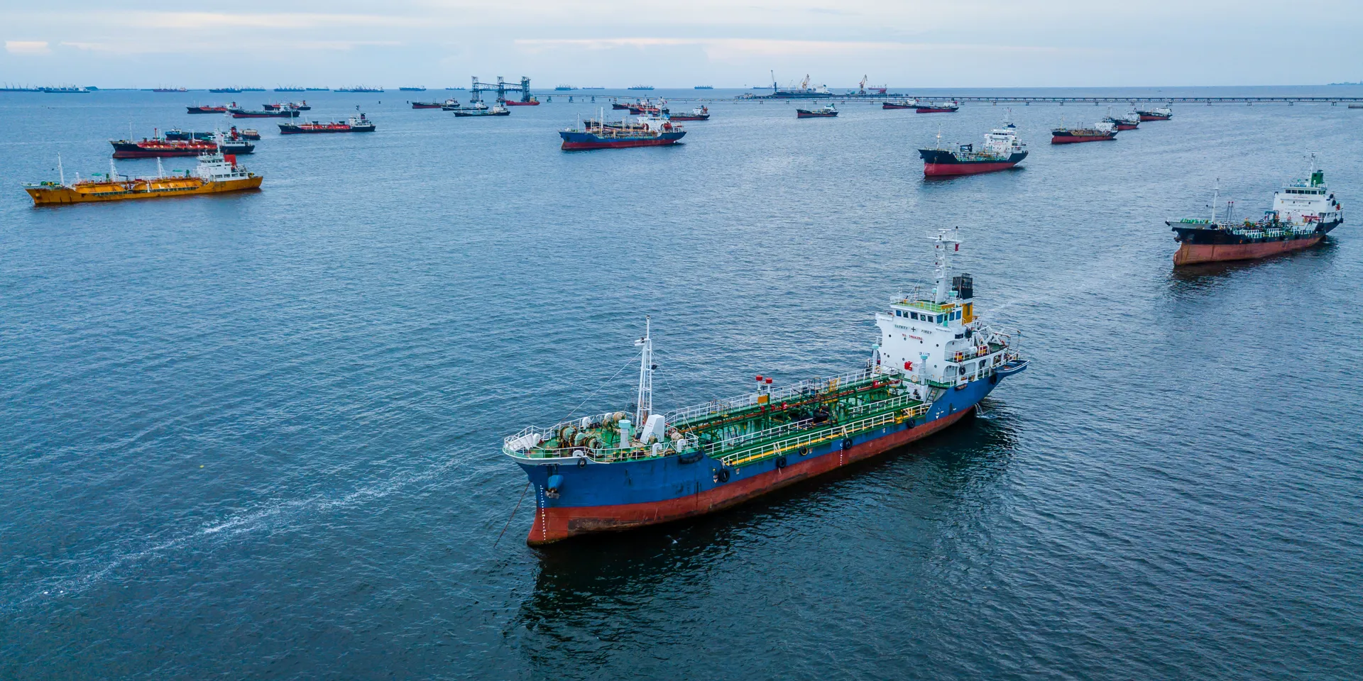 Several ships anchored in calm blue waters.