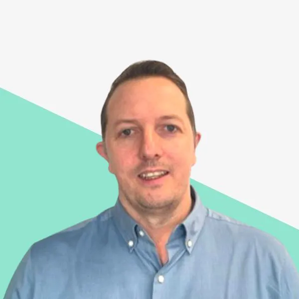 Man in a blue shirt against a light background.