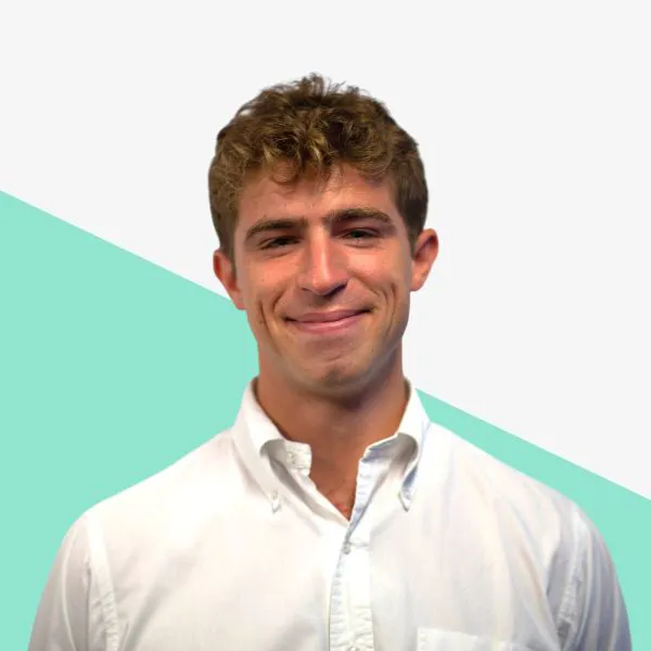 Smiling man in a white shirt with a green background.