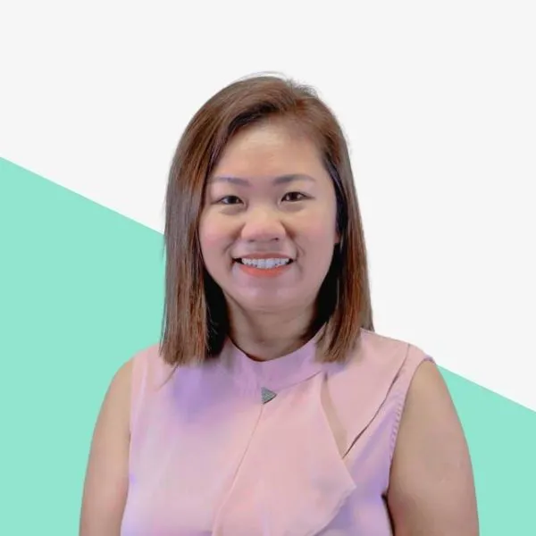 Smiling woman in a pink top against a light background.