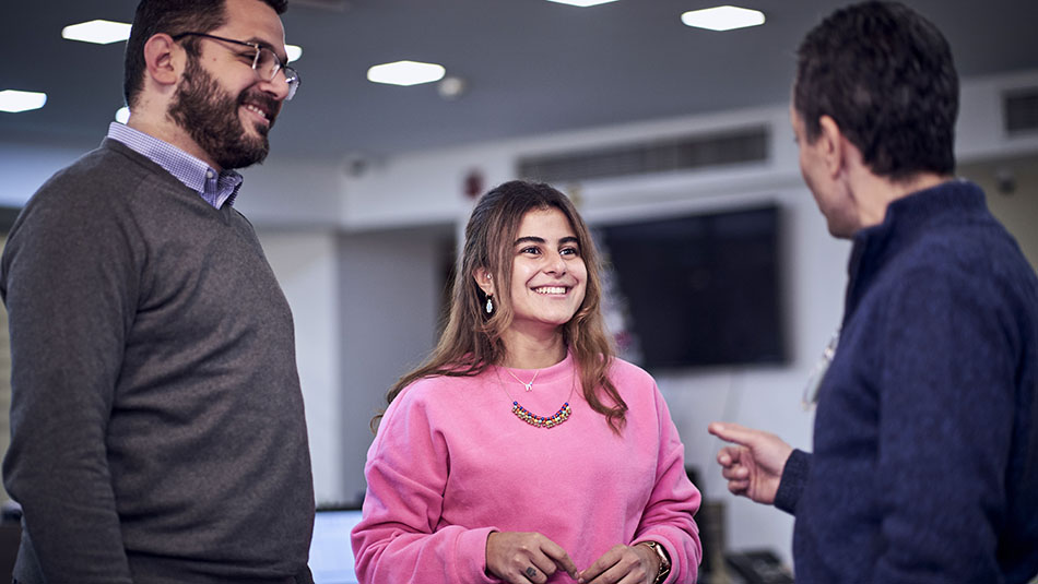 woman and two men talking in a group