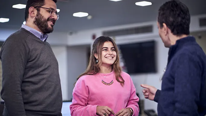 woman and two men talking in a group