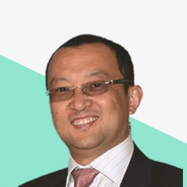 Smiling person with glasses, wearing a suit and tie.