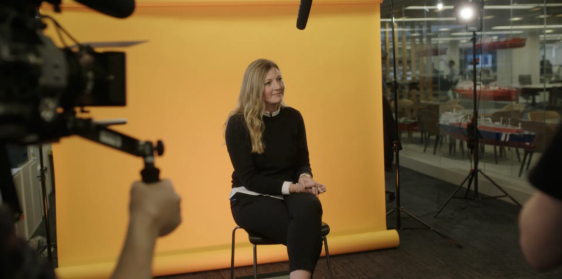 woman sitting in front of film set with yellow background