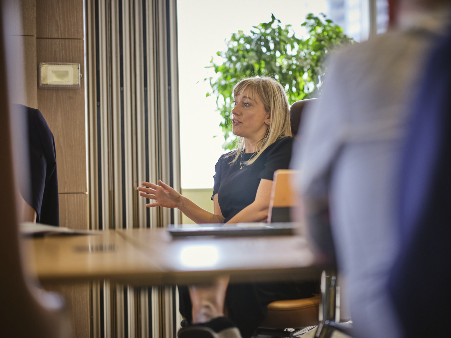 woman sitting talking and gesturing in a meeting