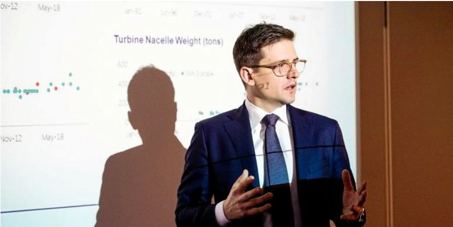 Man in a suit and glasses, neutral expression.