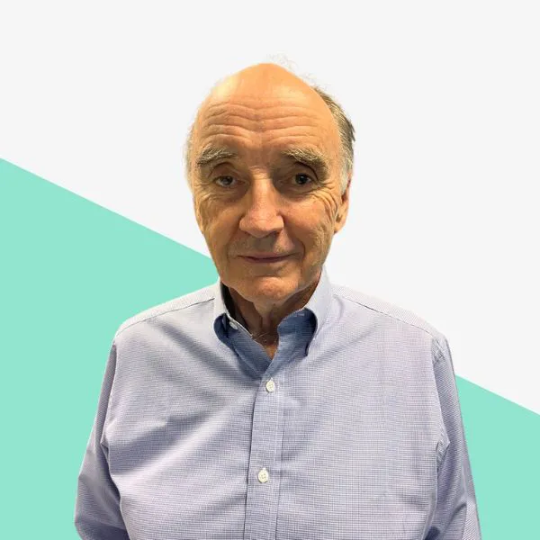 Older man in a light blue shirt, neutral background.