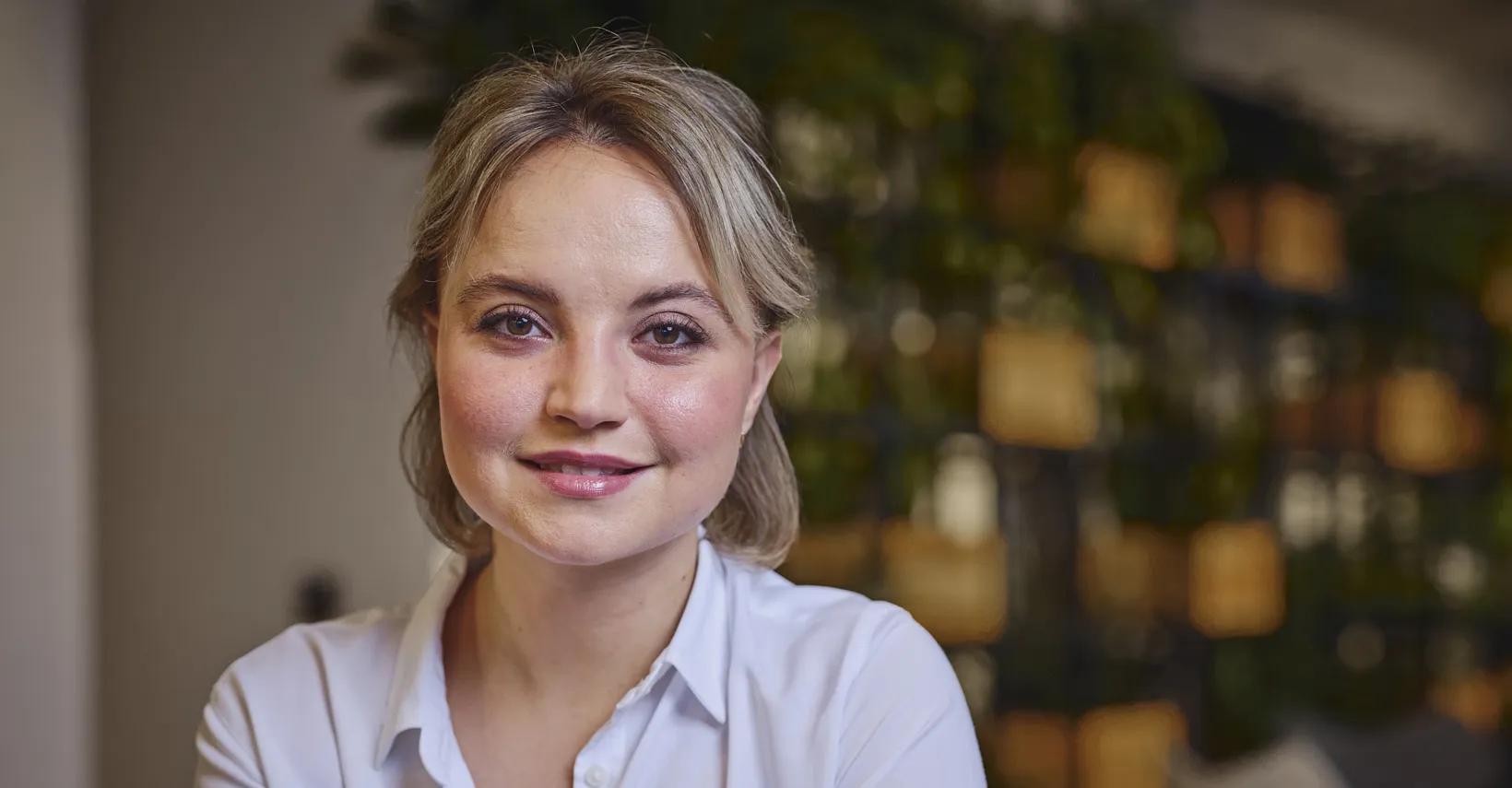 woman in white shirt sitting and smiling