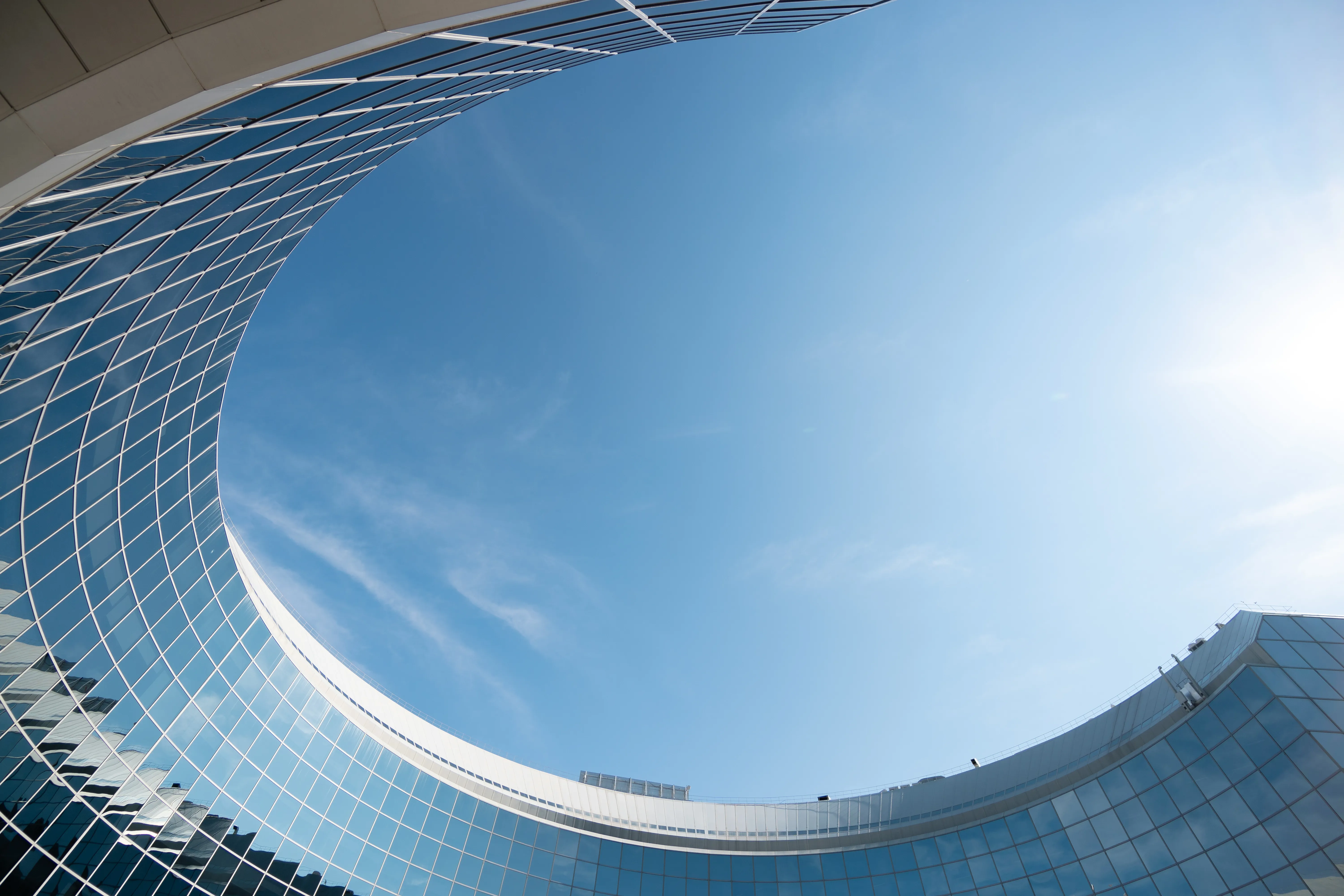 Curved building facade against a blue sky.