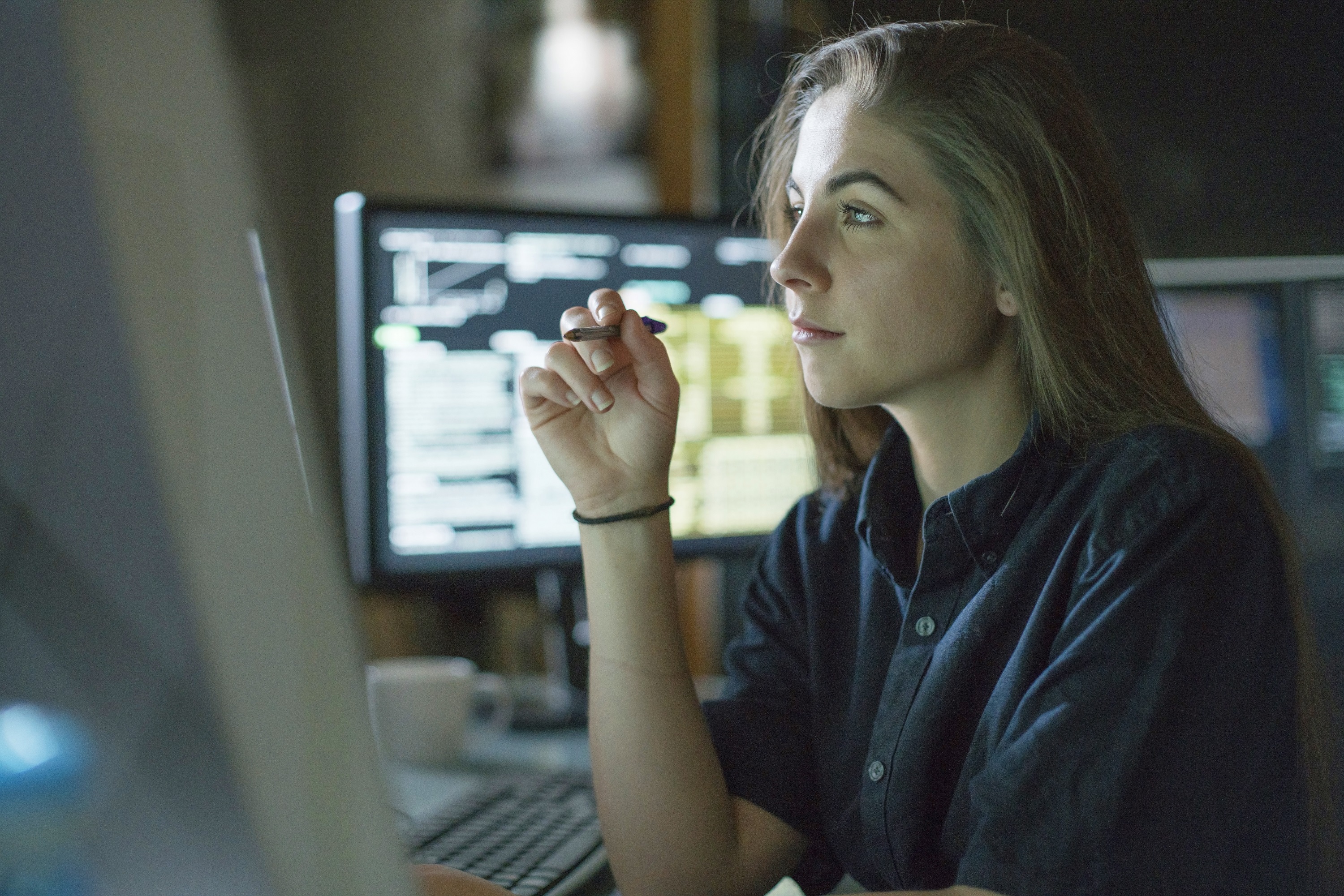 Woman looking at screen with pen