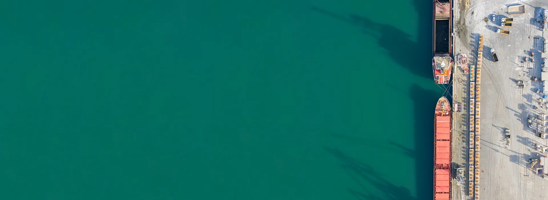 Aerial view of boats by a turquoise harbor.