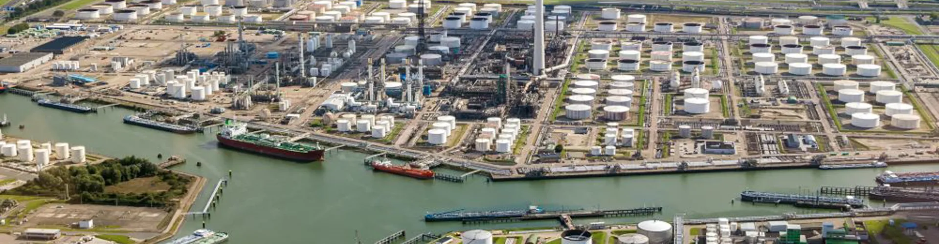Aerial view of oil tankers moored at a oil storage terminal and oil refinery in a port.