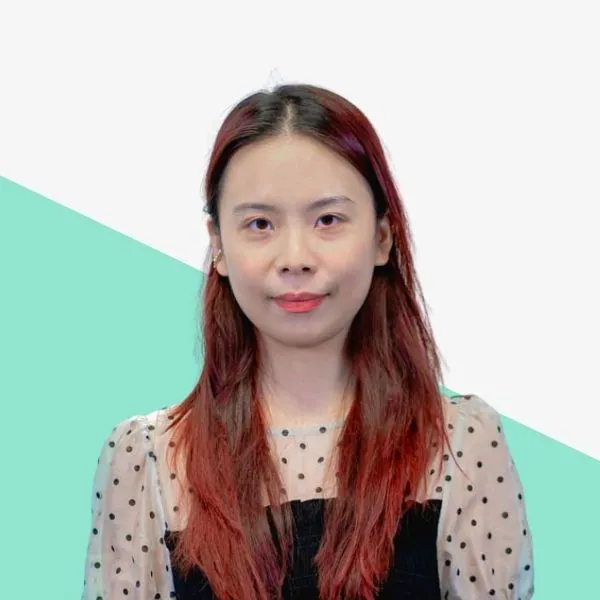 Person with long, wavy hair in a polka dot blouse.