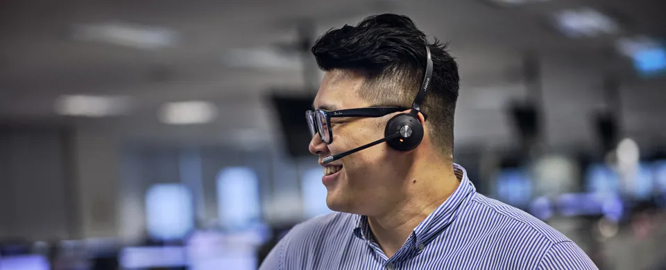 Clarksons broker in Singapore office with headset